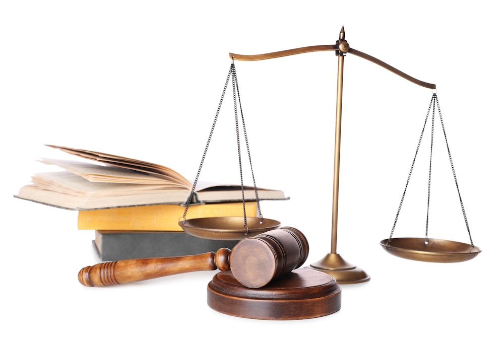 Wooden gavel, books and scales of justice on white background